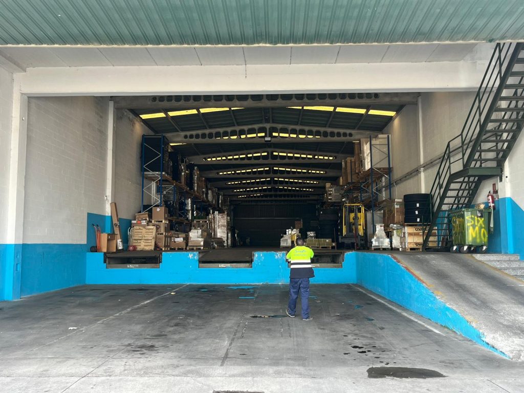 Interior del almacén de Transportes Sixto con un trabajador en el área de carga y descarga.