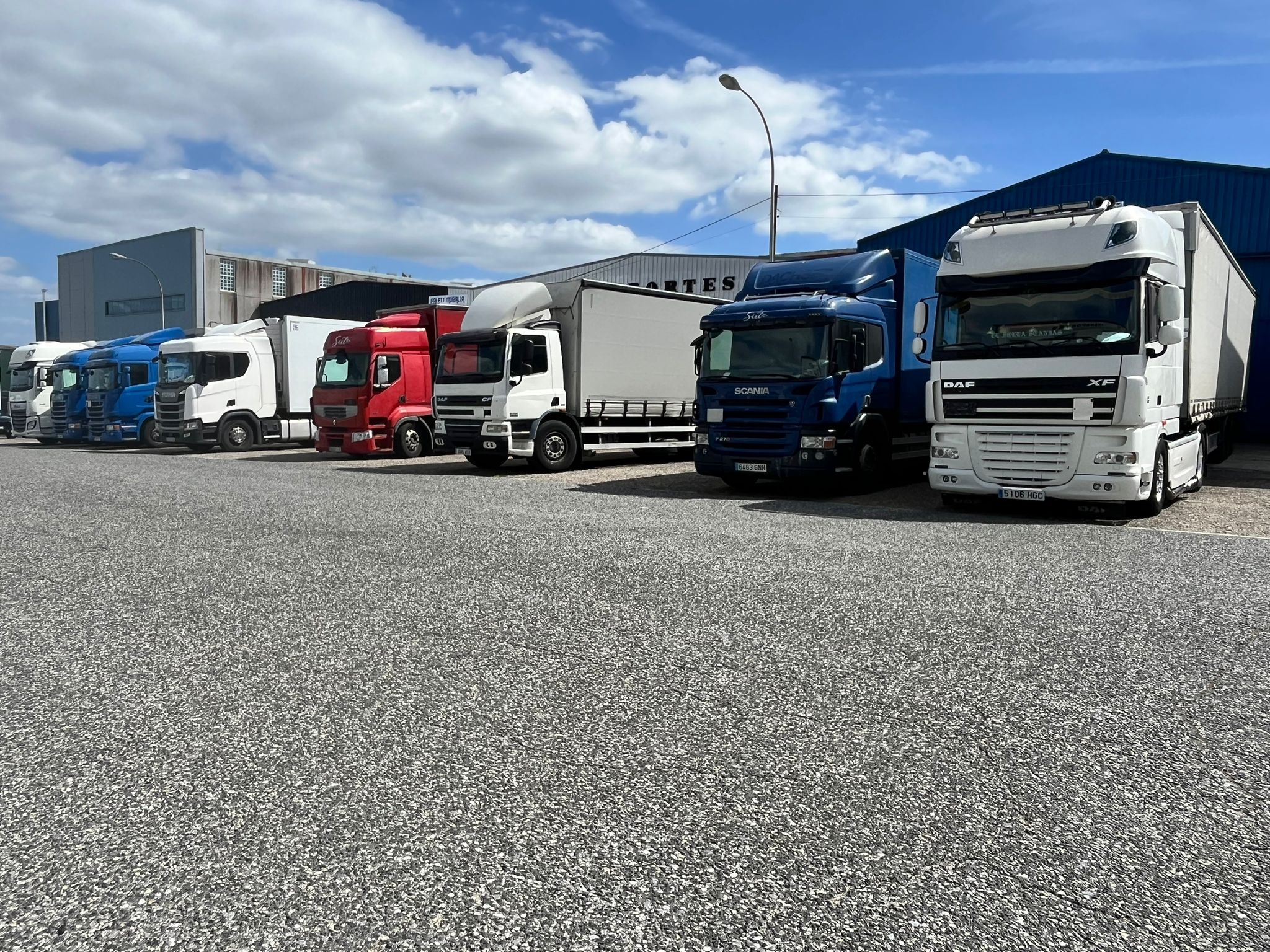 Parte de la flota de camiones de Transportes Sixto. Línea de camiones de Transportes Sixto estacionados en fila.